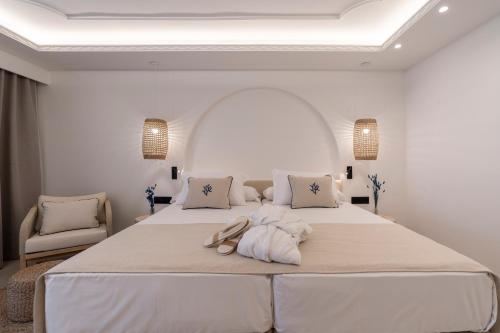a white bedroom with a large bed with towels on it at PONTIANA Thalasso Hotel in Oropesa del Mar