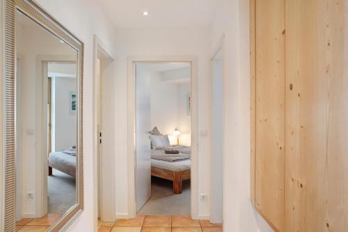 pasillo con espejo y dormitorio con cama en Apartment zum Wohlfühlen, en Garmisch-Partenkirchen