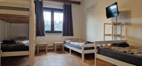 a room with three bunk beds and a flat screen tv at Apartmenthaus MITTERFELD in Mitterfeld