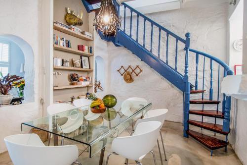 a dining room with a glass table and white chairs at See Table Mountain from a Historic Home in Cape Town