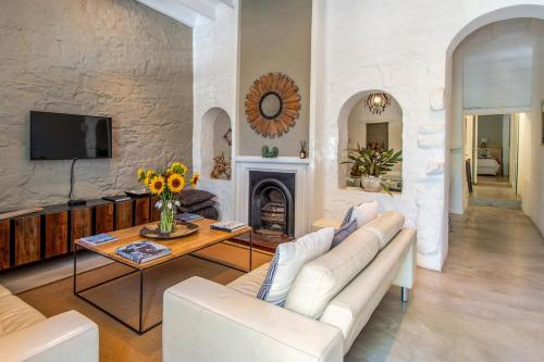 a living room with a white couch and a fireplace at See Table Mountain from a Historic Home in Cape Town