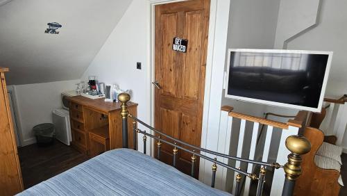 a bedroom with a bed and a flat screen tv at Sunny Family Residence with parking. Jacuzzi bath perfect for relaxing and unwinding in Kent