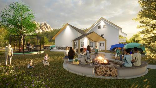 a group of people sitting around a fire in front of a house at Campingresort Hinterstoder in Hinterstoder