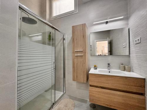 a bathroom with a sink and a glass shower at Casa Fe in Morro del Jable