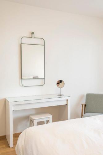 a bedroom with a white desk and a mirror at Modern appt opposite theatre, 7 min walk to Messe in Klein-Basel