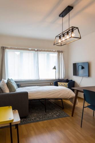 a living room with a large bed and a couch at Modern appt opposite theatre, 7 min walk to Messe in Klein-Basel