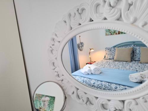 a bedroom with a mirror and a bed at TOLUAMMARE Sicily in Santa Maria Del Focallo