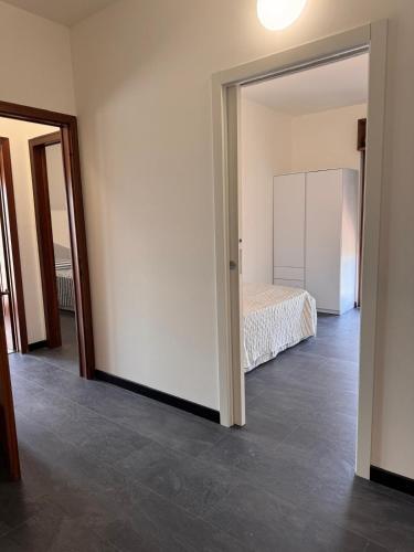 an empty room with a bed and a mirror at Casa Aris in Monfalcone
