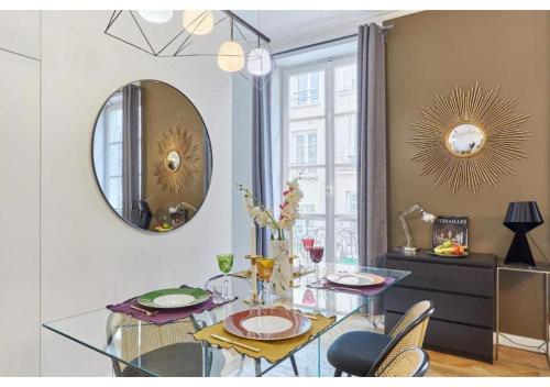 une salle à manger avec une table en verre et un miroir dans l'établissement Apartment Le Marais by Studio prestige, à Paris