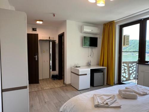 a bedroom with a bed and a desk and a window at BLISS Dubova in Dubova