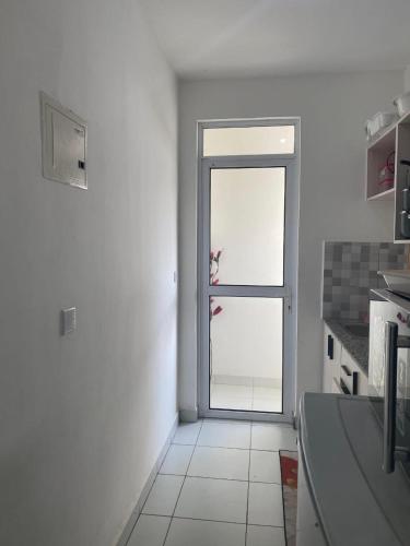 a white kitchen with a door to a window at Tabbys staycation in Mombasa