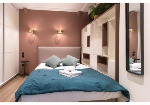 une chambre avec un lit avec des draps bleus et un miroir dans l'établissement Apartment Saint Germain des Près by Studio prestige, à Paris