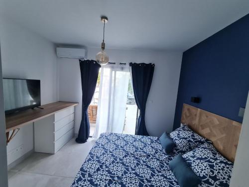 une chambre avec un lit et une porte coulissante en verre dans l'établissement Séjournez à 3 min des remparts confort et accessibilité, à Aigues-Mortes