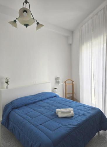 a bedroom with a blue bed with a towel on it at A Casa dei Miei in Otranto