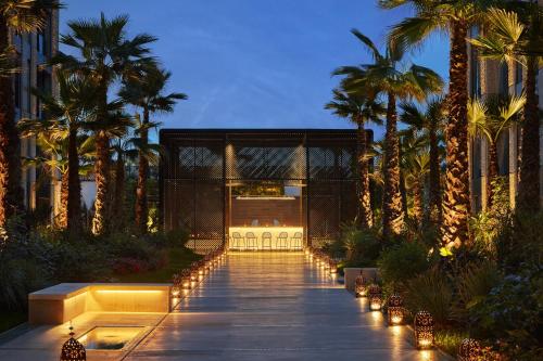 a walkway with palm trees and lights in a building at Four Seasons Hotel Casablanca in Casablanca