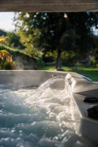 a bath tub filled with water with the water coming out at Maison La Belle Cosy 2-bedroom house with jacuzzi & airco in Zoutleeuw