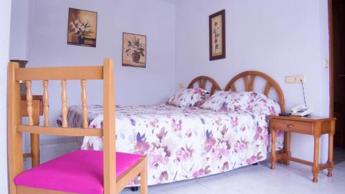a bedroom with a bed and a phone on a table at Hotel Candano in Isla