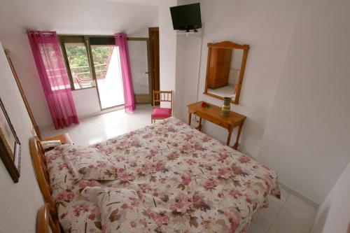 a bedroom with a bed and a mirror and a table at Hotel Candano in Isla