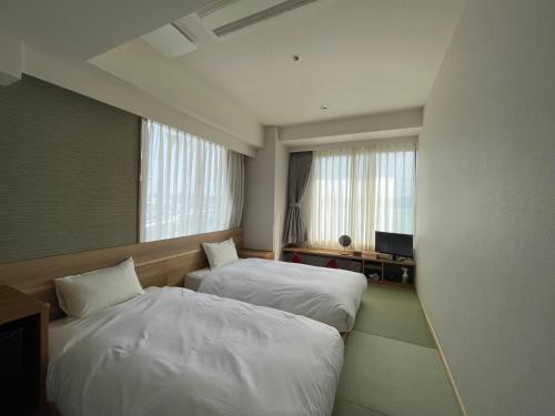 Postel nebo postele na pokoji v ubytování Matsue New Urban Hotel
