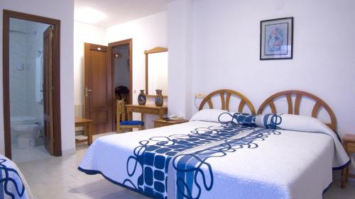 a bedroom with a bed with a blue and white blanket at Hotel Candano in Isla