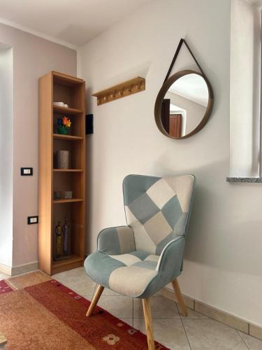 a living room with a chair and a mirror at Casa Vacanze Aurora in Coccorino