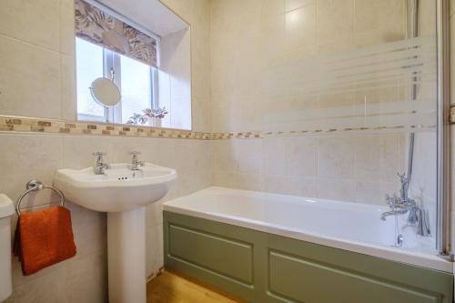 a bathroom with a sink and a bath tub at Victory Cottage in Ambleside