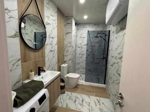 a bathroom with a shower and a sink and a mirror at Central Park 7 in Burgas City