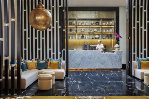 a lobby with couches and a bar with a chef in the kitchen at Four Seasons Hotel Casablanca in Casablanca