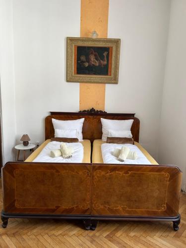 a wooden bed in a room with a picture on the wall at Velez Ház in Budapest