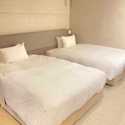 Postel nebo postele na pokoji v ubytování Matsue New Urban Hotel