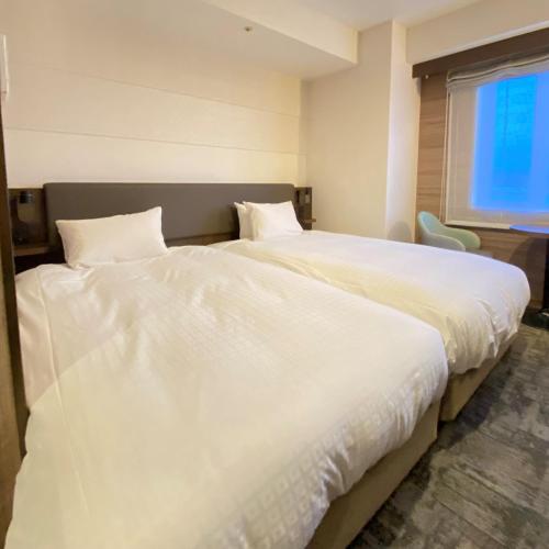 Postel nebo postele na pokoji v ubytování Matsue New Urban Hotel