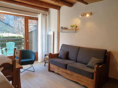 d'un salon avec un canapé et un balcon. dans l'établissement Petit chalet 4 pers Champagny-en-Vanoise, à Champagny-en-Vanoise
