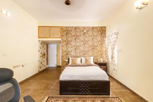 a bedroom with a bed and a chair in it at Canvas43 Eco Villa DailyHK EVCharging in Bengaluru
