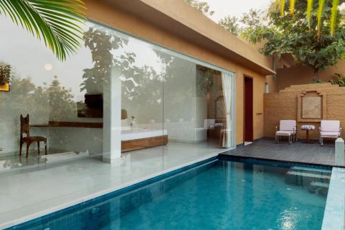 a house with a swimming pool and a bathroom at YAAN Udaipur in Udaipur
