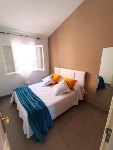 a bedroom with a bed with orange and blue pillows at Dúplex Casa Nerea in Santa Cruz de la Palma