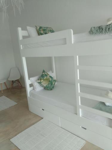 a white bunk bed with two pillows on it at Tropicana Guesthouse in Ponta do Ouro