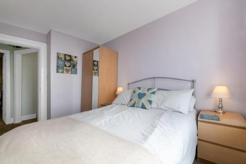 a bedroom with a white bed with a blue pillow at Aberdyfi Sea View Apartment in Aberdyfi