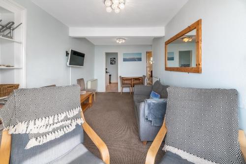 a living room with a couch and a table and a mirror at Aberdyfi Sea View Apartment in Aberdyfi