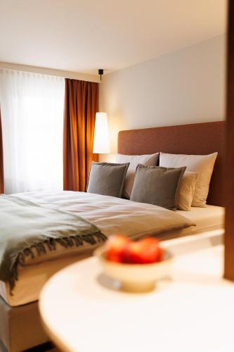 a bedroom with a bed with a bowl of fruit on a table at Boutiquehotel Ochsen in Lenzkirch