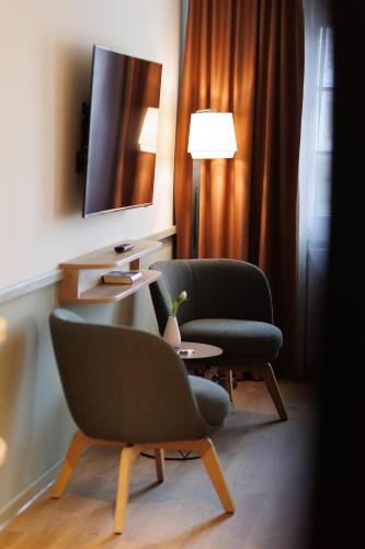 a room with two chairs and a table and a tv at Boutiquehotel Ochsen in Lenzkirch
