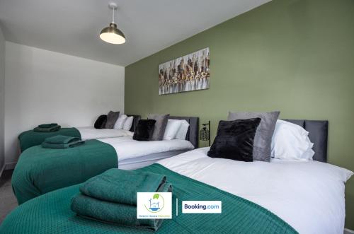 a room with three beds with green and white at Cosy Retreat By Green Haven Escapes Short Lets & Serviced Accommodation Seacroft With Free Off-Street Parking & Pet-Friendly in Killingbeck