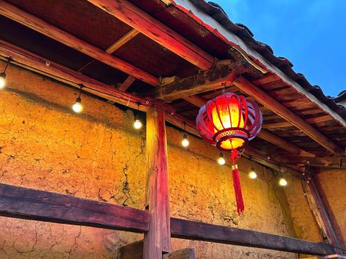 a red lantern hanging from the ceiling of a building at SUNG Home in Dồng Văn
