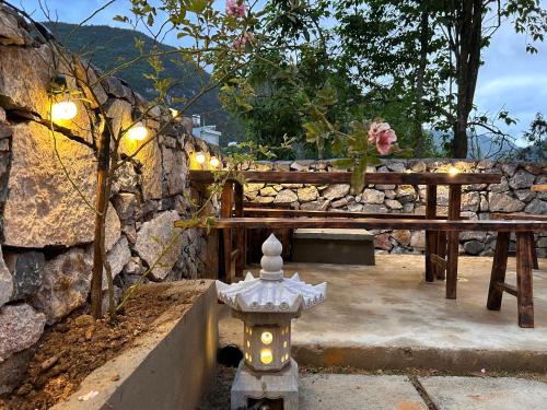 a fire hydrant sitting next to a stone wall at SUNG Home in Dồng Văn