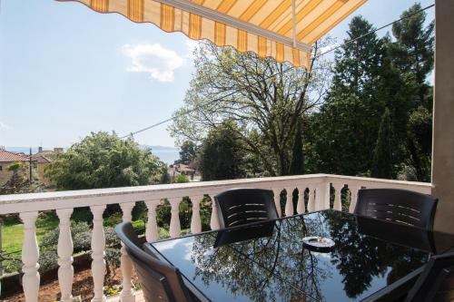 a balcony with a table and chairs on a fence at Apartments Villa Salona in Opatija