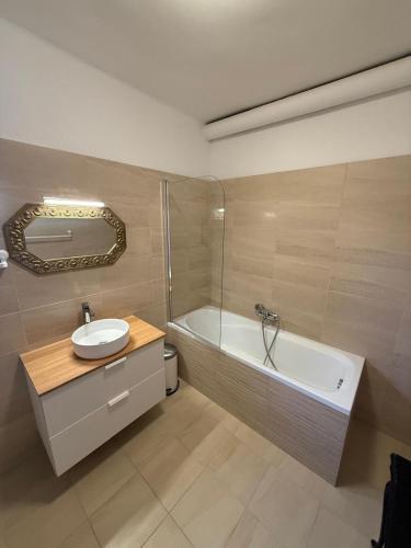 a bathroom with a tub and a sink and a bath tub at HősCincér Apartment Marót in Pilismarót