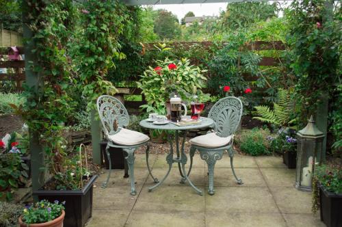 a table and chairs in a garden with roses at Kirkstyle Hideaway in Arbroath
