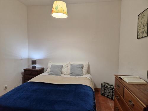 a bedroom with a bed with a blue blanket at Casa do Beco do Chantre I in Évora