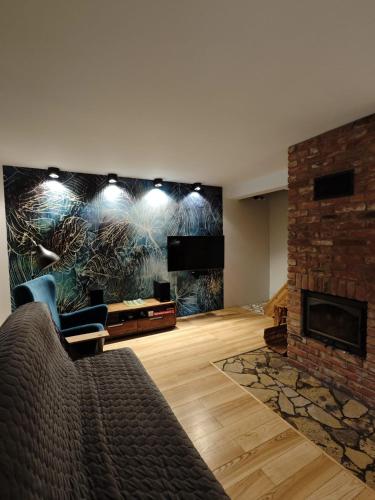 a living room with a couch and a fireplace at Leśny Relaks in Krasiejów