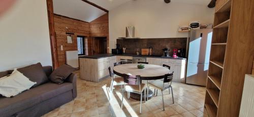 un salon avec un canapé et une table dans une cuisine dans l'établissement Domaine le Bouissou Du Mahun Gîtes de groupes en pleine forêt Ardéchoise, à Saint-Symphorien-de-Mahun