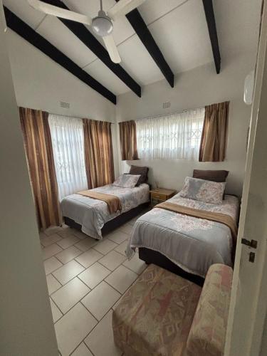 a bedroom with two beds and a ceiling fan at Natspat 10 in Margate